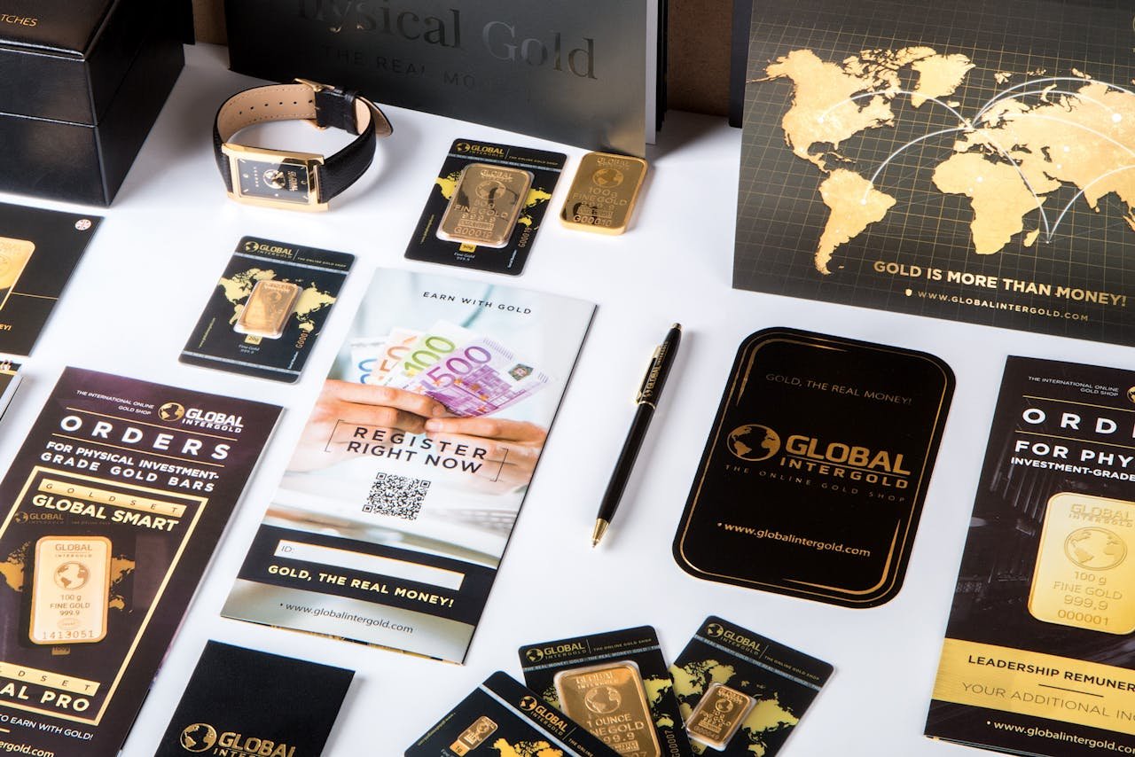 Crafting Captivating Headlines: Your awesome post title goes here Flat lay of promotional materials for gold investment, featuring brochures, cards, and gold bars.